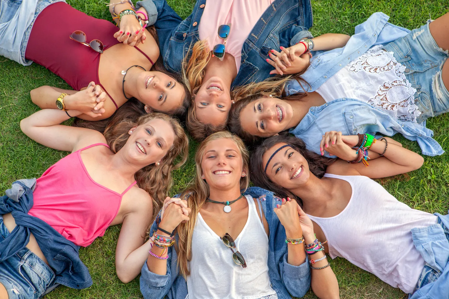 Frauenarztpraxis Dr. A. Dietrich - Gesundheitsdienste für Frauen - Eine Gruppe Teenager-Mädchen liegt lächelnd im Gras.