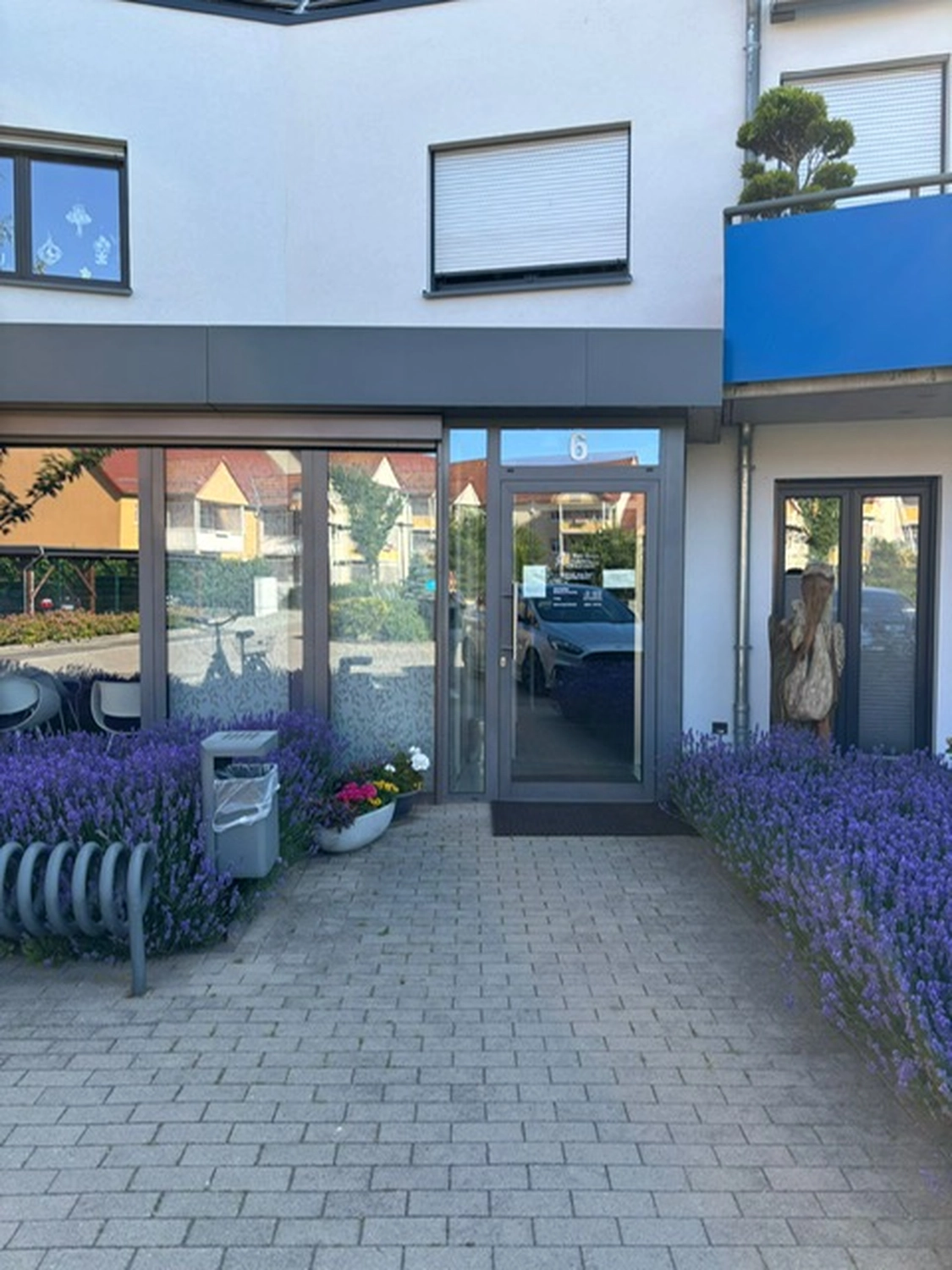 Frauenarztpraxis Dr. A. Dietrich - Gesundheitsdienste für Frauen - Vorderansicht einer Klinik und eine lila Blume an der Seite